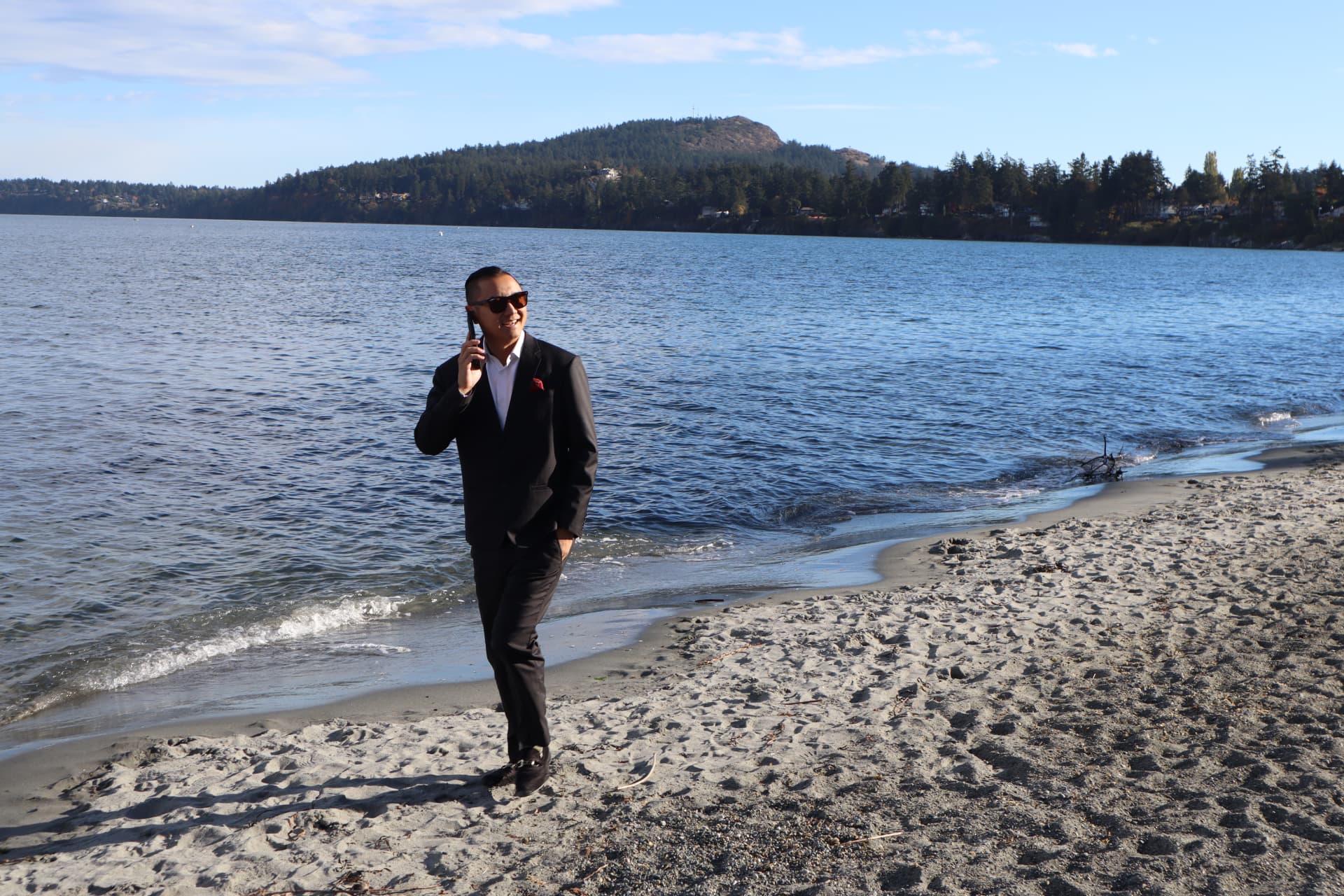 Randy Loo walking the shoreline with a phone in hand